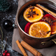 Mulled wine in a saucepan with spices and oranges